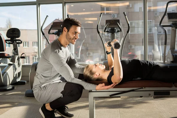 Entrenador personal mostrando ejercicios con pesas — Foto de Stock