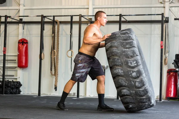 Bodybuilder flipping tire at the gym