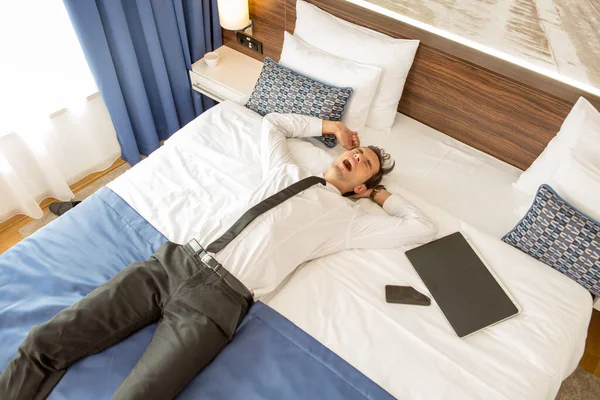ホテルのベッドでスーツに身を包んだビジネスマン — ストック写真