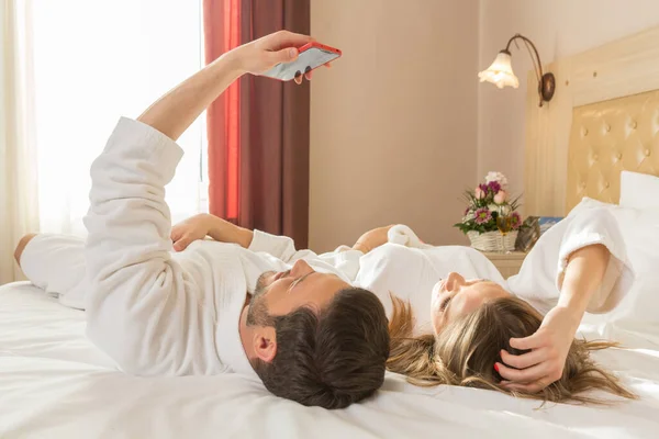 Attractive Young Couple Bathrobe Taking Selfie Hotel Bed — Stock Photo, Image
