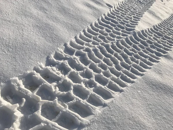 Rastros del vehículo terrestre en la nieve —  Fotos de Stock