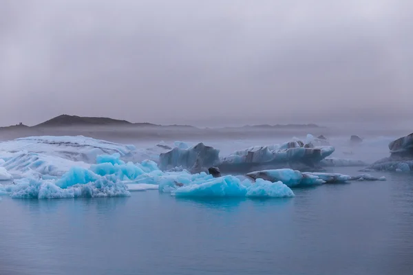 夕暮れ Fjallsarlon 氷河湖に浮かんでいる氷山。手配ラグーンに南 Iceland.Close/夕暮れ Fjallsarlon 氷河湖に浮かぶ氷山. — ストック写真