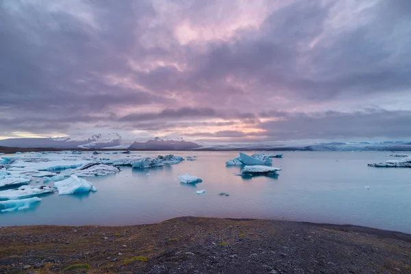夕暮れ Fjallsarlon 氷河湖に浮かんでいる氷山。手配ラグーンに南 Iceland.Close/夕暮れ Fjallsarlon 氷河湖に浮かぶ氷山. — ストック写真
