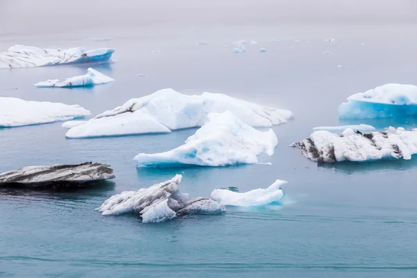 Icebergs flotando en el lago glaciar Fjallsarlon al atardecer. Islandia del Sur.Cerca de la laguna de Jokulsarlon. / Icebergs flotando en el lago glaciar Fjallsarlon al atardecer . — Foto de Stock
