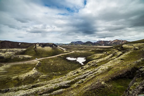 Дорога с машиной на поле в Исландии в пасмурный день — стоковое фото