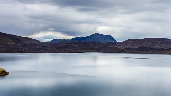 Lago con pequeña isla y reflejo del cielo en día nublado en Islandia — Foto de Stock