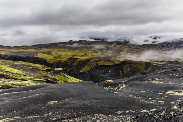 Dark Islandia paisagem com musgo verde e estrada preta, Islândia — Fotografia de Stock