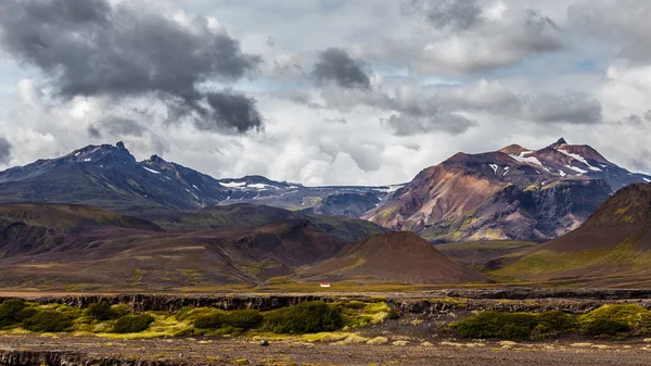 View on a huge mountain and small house in Iceland with dramatic sky — Φωτογραφία Αρχείου