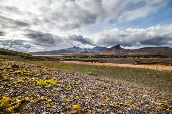 Vista sobre una enorme montaña y una pequeña casa en Islandia con un cielo dramático — Foto de Stock