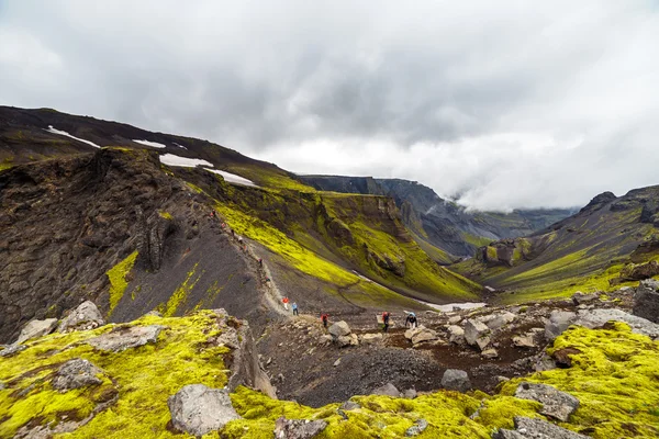 Grande colline avec sont en train d'escalader les touristes en Islande — Photo
