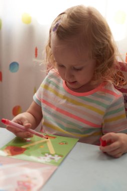 Evde online ders sırasında ödev yapmak, sosyal uzaklık karantinası Covid-19, kendini tecrit, online eğitim konsepti, evde eğitim. Çocuk evde, anaokulu kapalı. Anaokulundaki küçük kız..