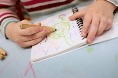 Çocuk elleri renkli kille oynuyor. Plastiksin. Hamur oynamak, sosyal mesafe karantinası Covid-19, kendini izole etmek, online eğitim konsepti, evde eğitim. Küçük kız evde, anaokulu kapalı..