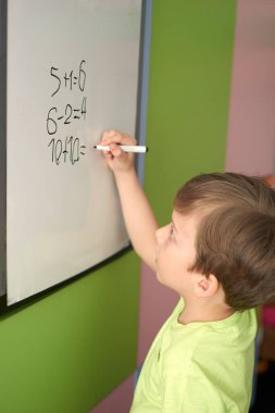 Çocuk elleri renkli kille oynuyor. Plastiksin. Hamur oynamak, sosyal mesafe karantinası Covid-19, kendini izole etmek, online eğitim konsepti, evde eğitim. Küçük kız evde, anaokulu kapalı..