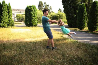 Mutlu baba-kız oynaşmaları ve sarılmaları. Aile yürüyüşü. Birlikte yaz zamanı, güneş ışığı. Babalar günün kutlu olsun..