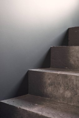 Siyah taş duvar köşesindeki merdivenleri kapatın. Siyah lobi. Sert beton merdiven. Siyah çelik korkuluklu. Büyüme konsepti. Minimalist iç tasarım.