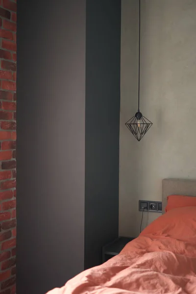 Lampa dekoracyjna wisząca na suficie przy łóżku. Minimalistyczny wystrój wnętrz. Stylowa sypialnia i salon. Szary ceglany mur w minimalistycznych meblach pokojowych projektanta. — Zdjęcie stockowe