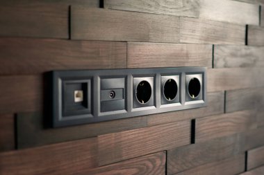 Elektrikli ev anahtarları ve prizler kapanıyor. Minimalist iç tasarım. Şık bir yatak odası ve oturma odası. Tasarımcı minimalist oturma odasındaki tahta tuğlalar. Tahta parke odası. Model için iç oda. İskandinav tarzı.