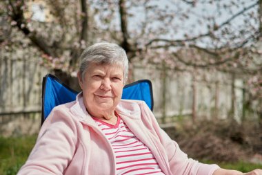 Kafasından vurulmuş, sakin, orta yaşlı, beyaz kadın kamp koltuğunda tek başına oturuyor. Huzurlu, düşünceli, olgun, yaşlı bir büyükanne, hayal kuruyor, meditasyon yapan serserileri rahatlatıyor. İyi eğlenceler..