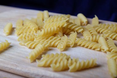 Vermicelli, makarna, sarmal makarna ahşap tahtada, mavi arka planda