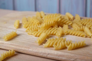Vermicelli, makarna, sarmal makarna ahşap tahtada, mavi arka planda