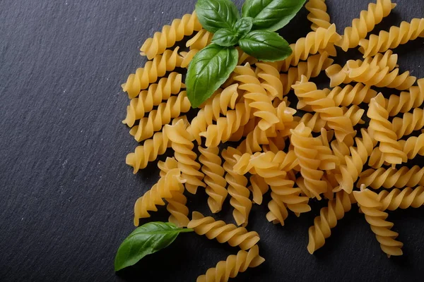 Vermicelli Massas Macarrão Espiral Manjericão Sobre Uma Superfície Pedra Preta — Fotografia de Stock