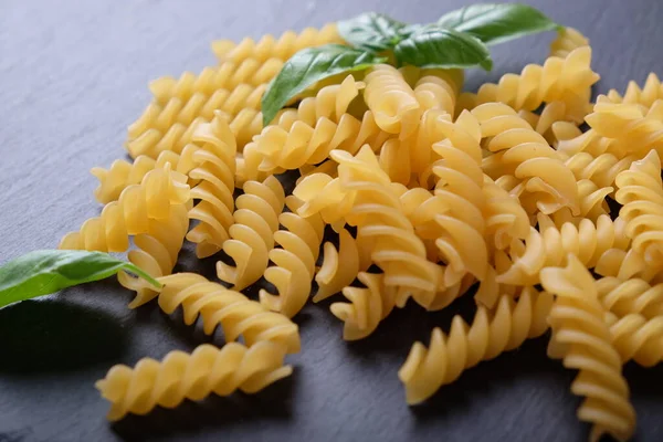 Vermicelli Massas Macarrão Espiral Manjericão Sobre Uma Superfície Pedra Preta — Fotografia de Stock