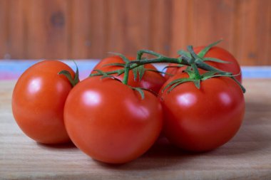 Tahta kesme tahtasının üzerinde domates dalı