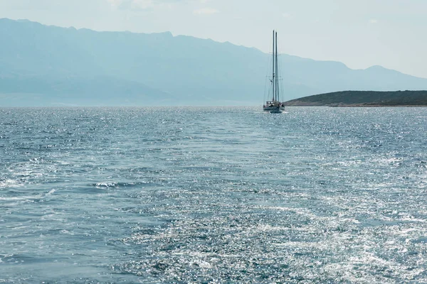 The yacht is sailing at Adriatic Sea and in the background you can see the Biokovo Mountains, Croatia in summer
