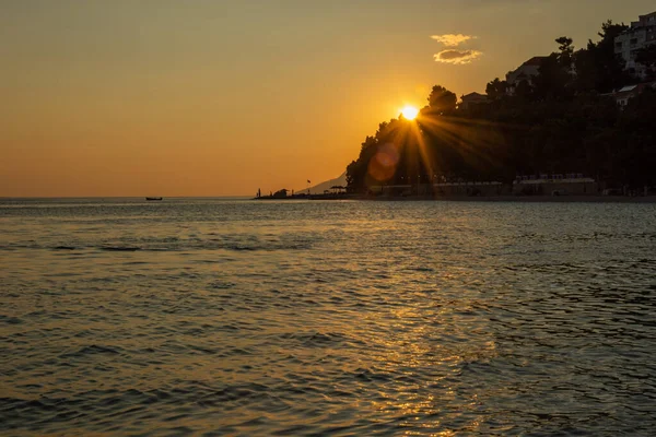 Hırvatistan 'ın Makarska Riviera kentinden Adriyatik' te yazın dağın arkasındaki batan güneşin manzarası