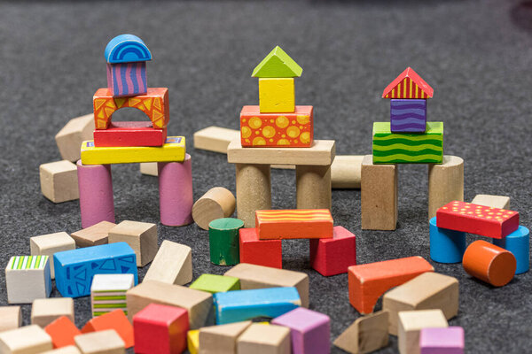 towers made of colorful wooden blocks arranged on a gray floor