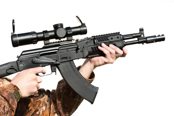 A man is holding a rifle magazine camouflage clothes