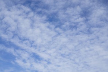 Yukarıya doğru, yumuşak ve beyaz bulutların dalgası Derin mavi gökyüzünün altında