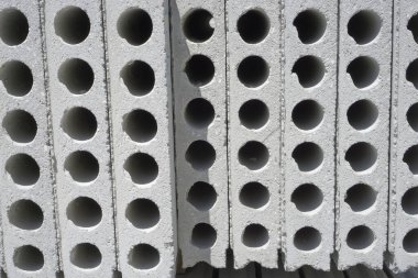 İnşaat için kenarı delik olan bir yığın önceden yapılmış beton malzeme.