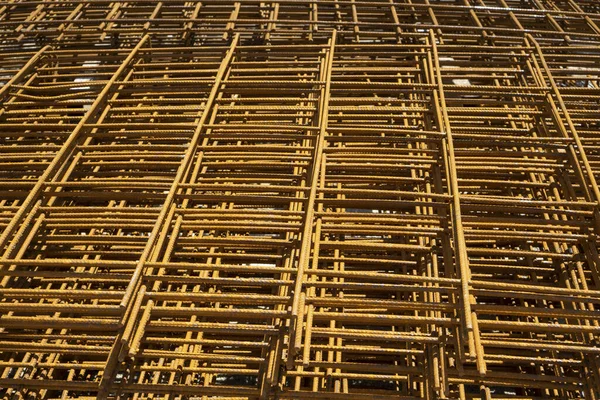 İnşaatta binanın önündeki beton zeminde pasla kaplanmış tel örgülü çelik yığını.