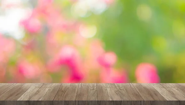 Kahverengi, eski, ahşap masa masası ve Bokeh resim üzerine kopyalama alanı pembe çiçek ve yeşil yapraklardan gelen bulanık arkaplanlar
