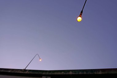 Gece arkaplanında koyu mavi gökyüzünün altında, süper otoyolda iki direk ışığı, solucan gözleri fotoğrafı.