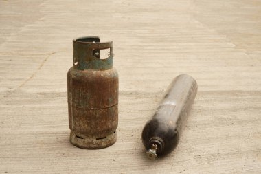 Sert zemin üzerinde iki eski benzin deposu.