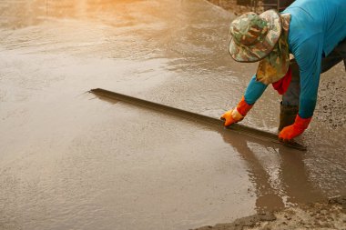 Yere beton yapıştıran bir işçi.