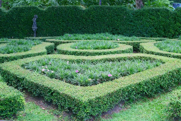 Küçük bir İngiliz kır evi biçimi, sol tarafta bir heykel ve arka planda Fukien çayı kesilmiş bir duvar.