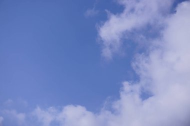 Derin mavi gökyüzünün altında beyaz kabarık bulutlar