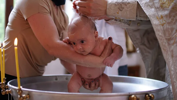 O sacramento do batismo. A baptizar o bebé. Criança, padre e padrinho . — Fotografia de Stock