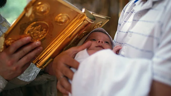 Het sacrament van de doop. Doop de baby. Kind, priester en peetvader. — Stockfoto