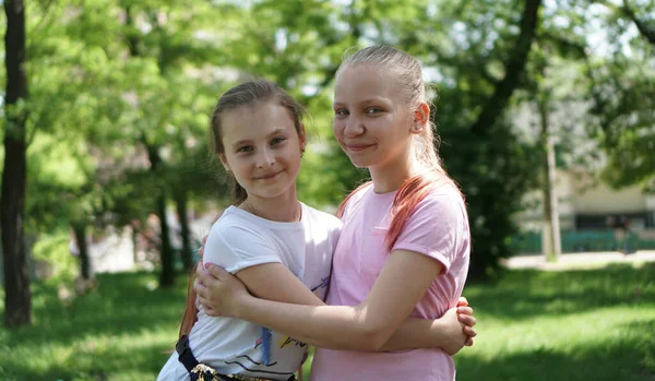 Портрет двух девушек, обнимающихся в парке летом — стоковое фото