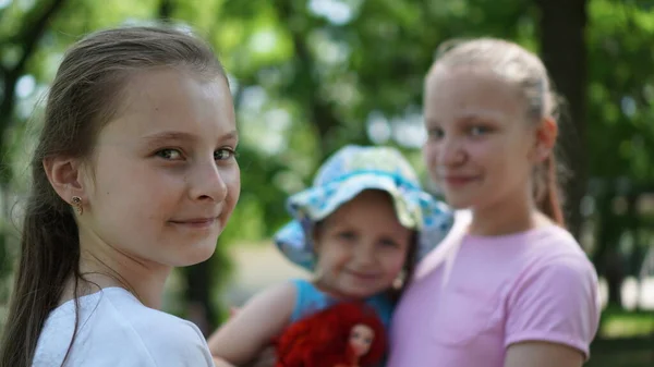 Porträt von drei lächelnden Mädchen, die im Sommer in einem Park posieren — Stockfoto
