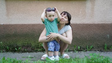 Komik bebek ve çömelmiş annesi ona sarılıyor.