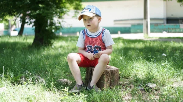 Menino sentado no coto no parque infantil — Fotografia de Stock