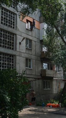 Evin duvarlarının yalıtımı. İşçi ipte sallanıyor.