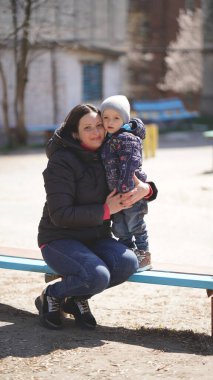 Güzel anne ve küçük tatlı oğlu baharda çocuk parkında. Mutlu aile ve bahar kavramı