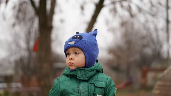 一个穿着绿色夹克 头戴可笑帽子 头上长着角的可爱小男孩的画像 孩子们转过头去 — 图库照片