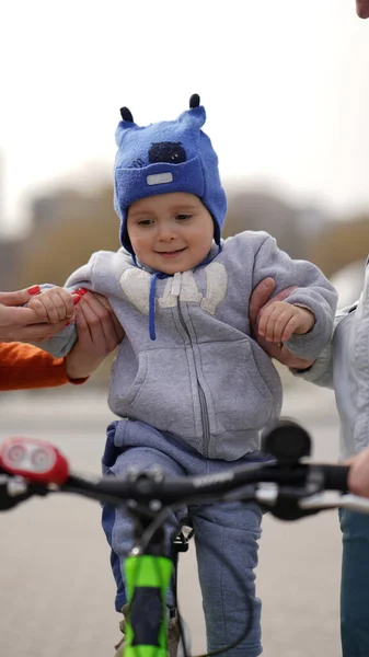 自転車で初めてバットマンの帽子を持つ小さなかわいい男の子 彼は興味があり 同時に怖がっています — ストック写真